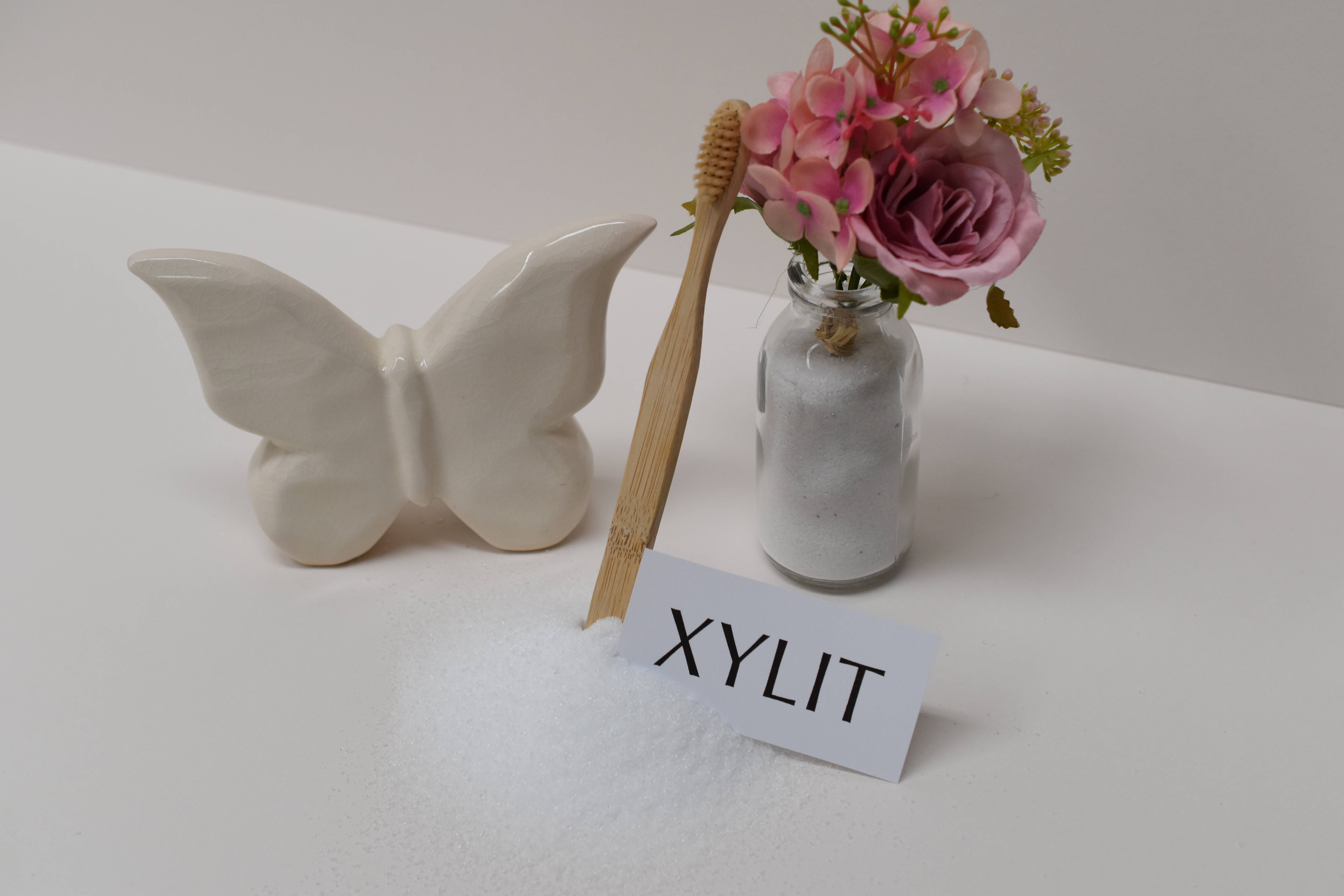 Xylit mit Zahnbürste, Schmetterlings-Deko und Blumen